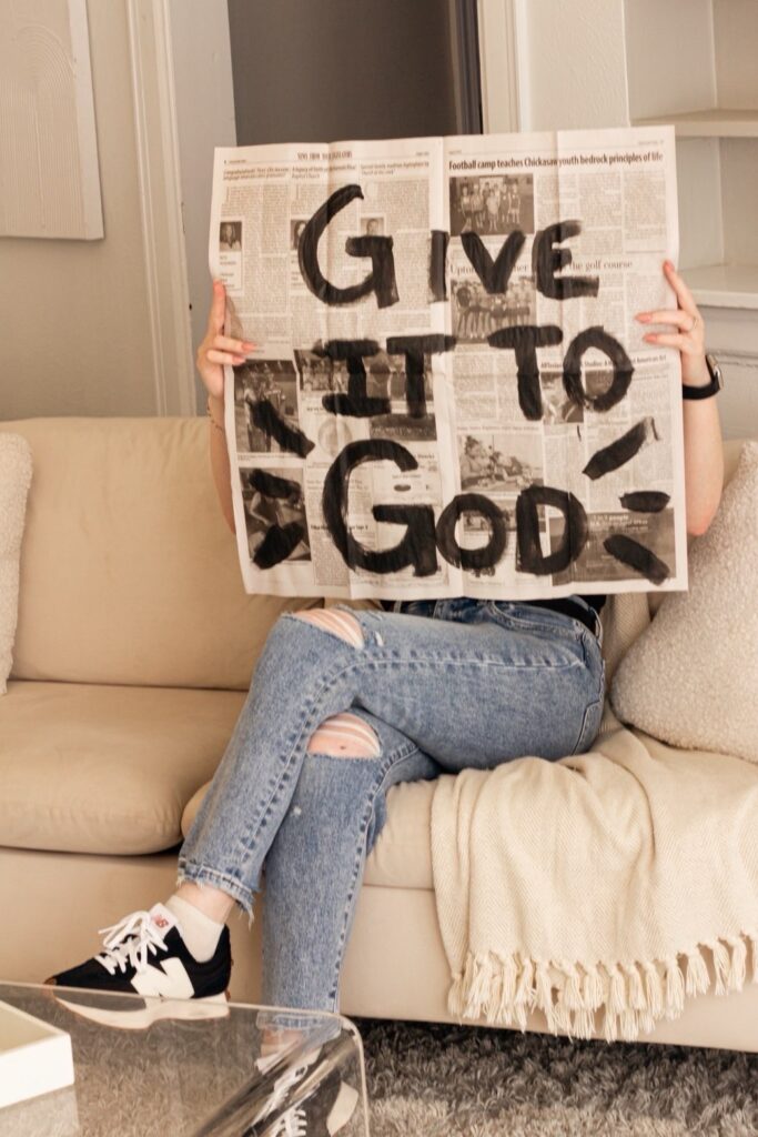 CARLY HOLDING A NEWSPAPER THAT SAYS "GIVE IT TO GOD"
