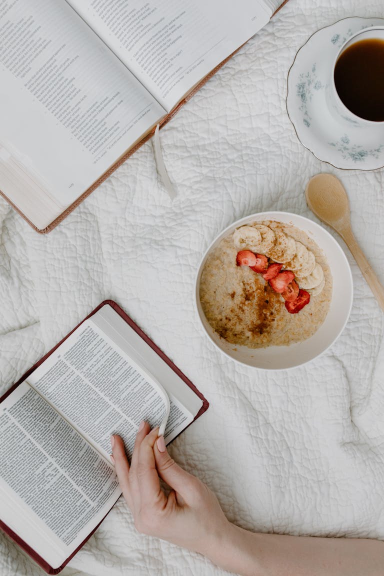 Top view of a morning routine with Bible reading, coffee, and healthy breakfast.
