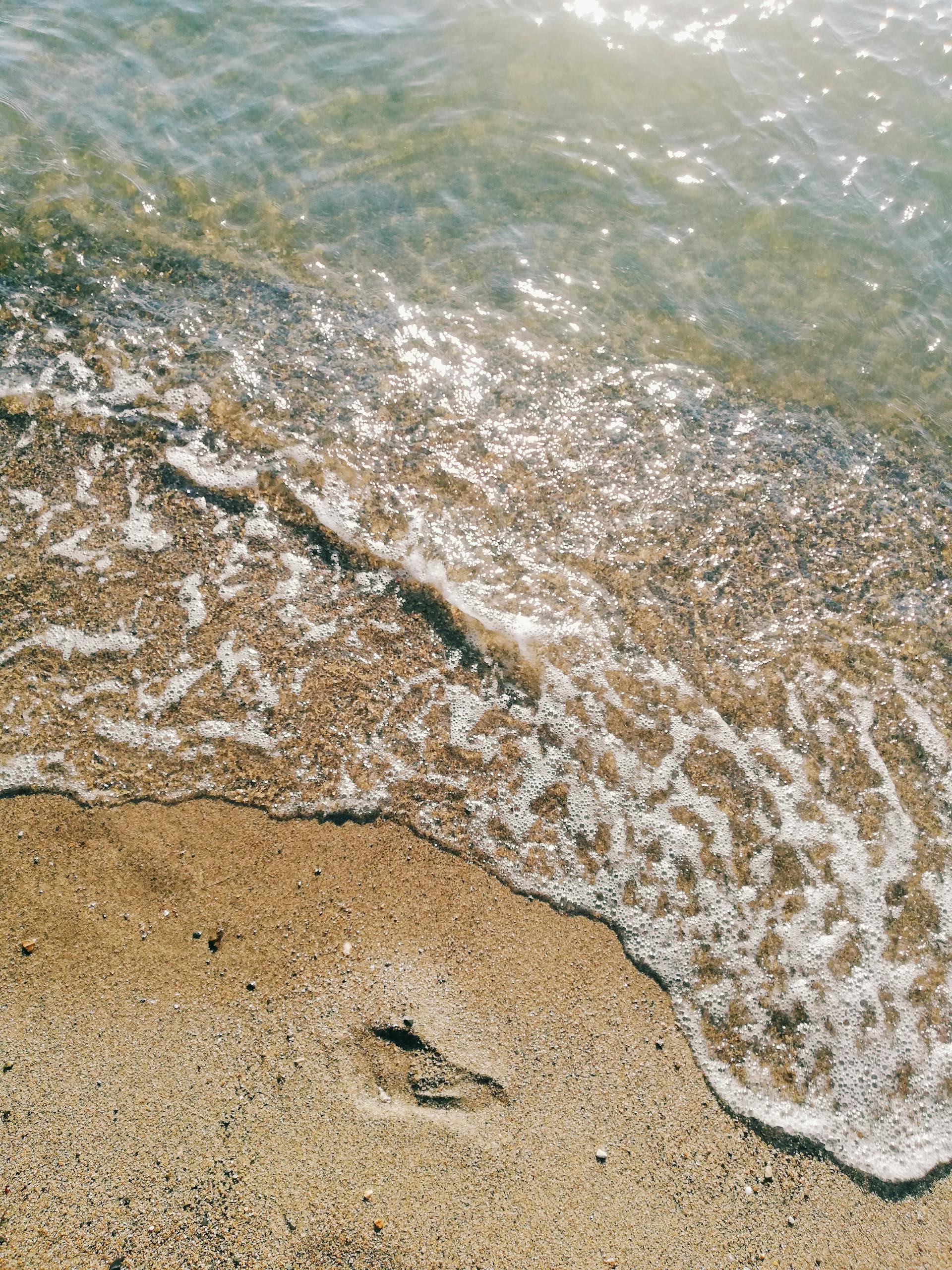 Gentle waves touching the sandy beach creating a peaceful seaside scene.