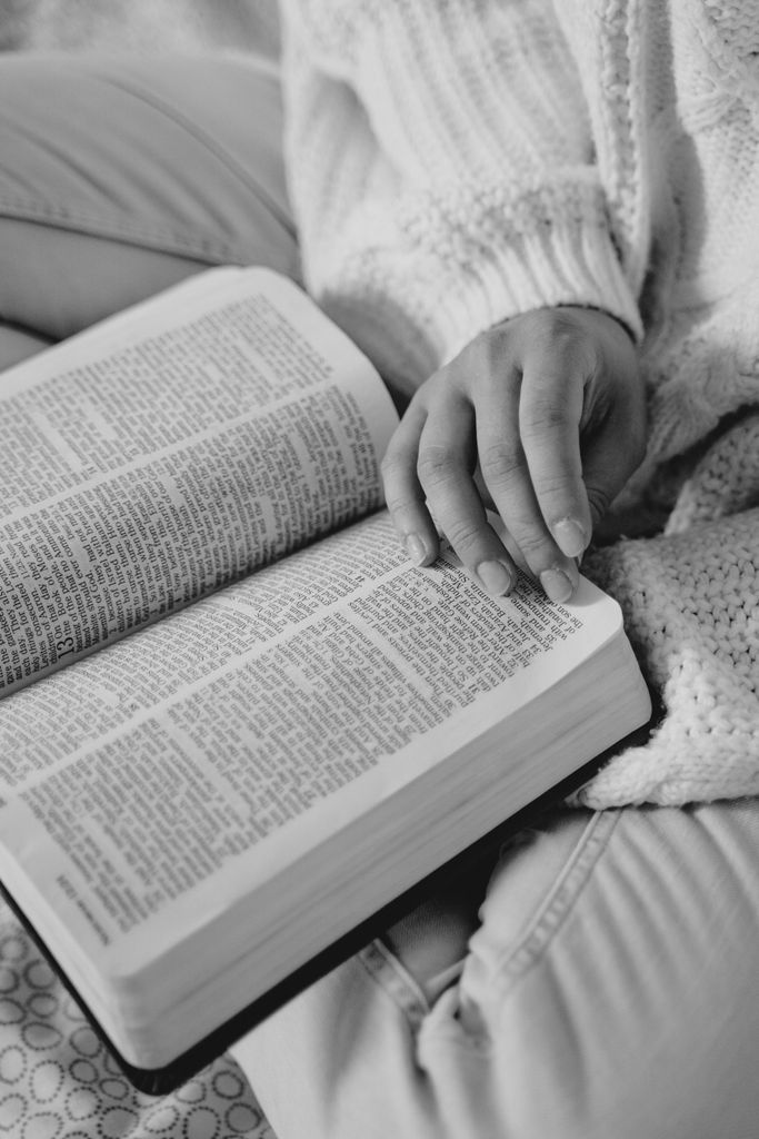 Black and white image of a woman sitting down and reading God's Word as she works on emotional healing through Christ.