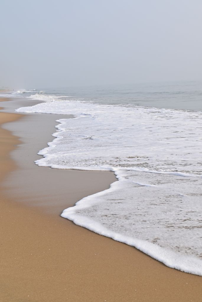 Calm waves wash the sandy shores of Chennai beach, capturing serene coastal beauty.