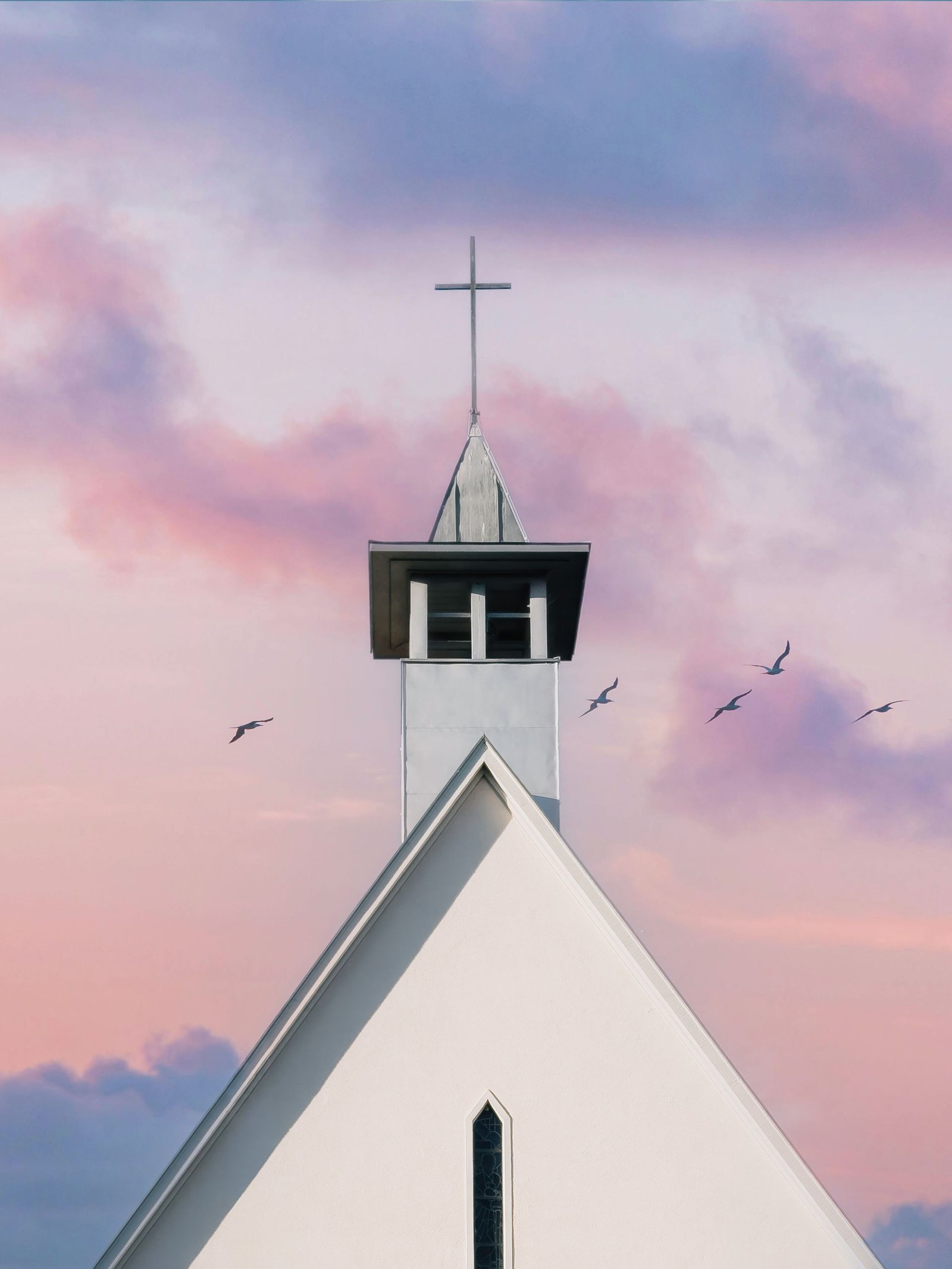 A beautiful church steeple against a sunrise sky, complemented by flying birds and pastel clouds, used for post regarding Christian conviction.